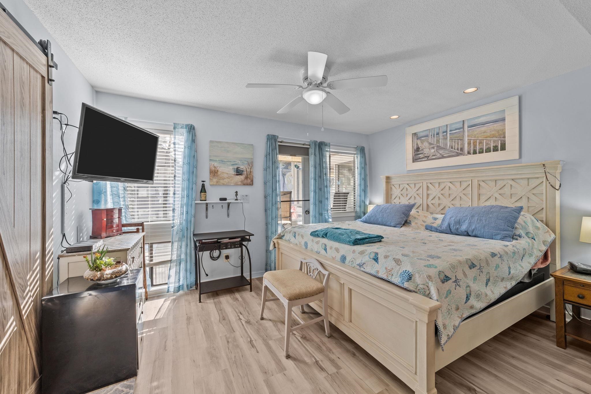 351 Lake Arrowhead Road, Unit 211 Myrtle Beach, SC 29572 - Photo 16 of 40 Bedroom with a barn door, light wood-style floors, ceiling fan, and a textured ceiling