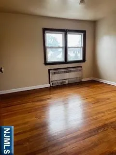 a view of a room with wooden floor and window