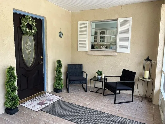 a kitchen with granite countertop a refrigerator a sink and white cabinets