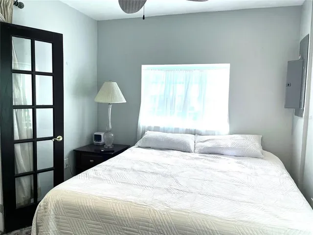 a backyard of a house with table and chairs plants and large tree