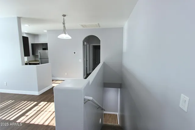 a view of a livingroom with wooden floor and staircase