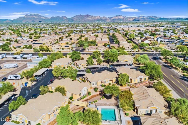 an aerial view of a city with lots of residential buildings and mountain view in back