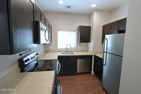a kitchen with stainless steel appliances a refrigerator sink and microwave