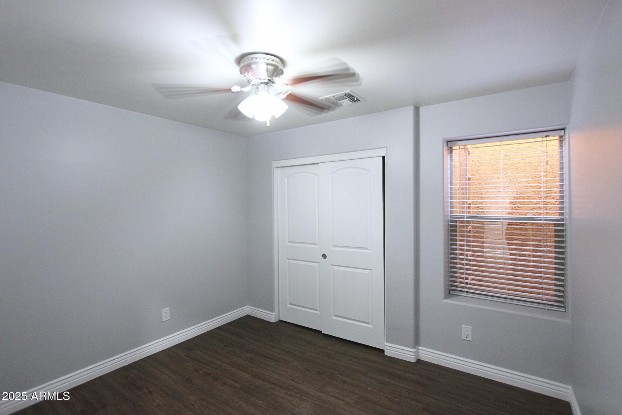 854 South San Marcos Drive, Unit A4 Apache Junction, AZ 85120 - Photo 9 of 22 a view of an empty room with wooden floor and a window