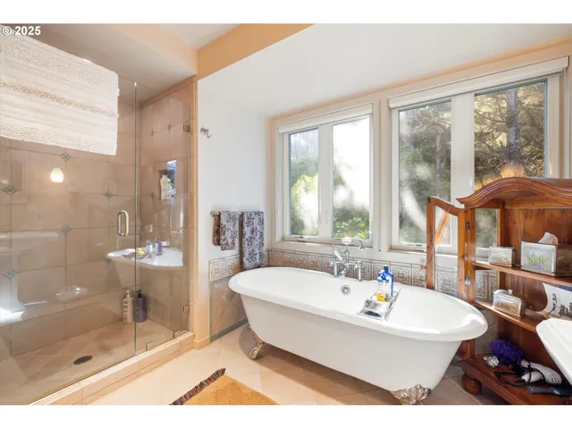 a bedroom with a bed a dresser and large window