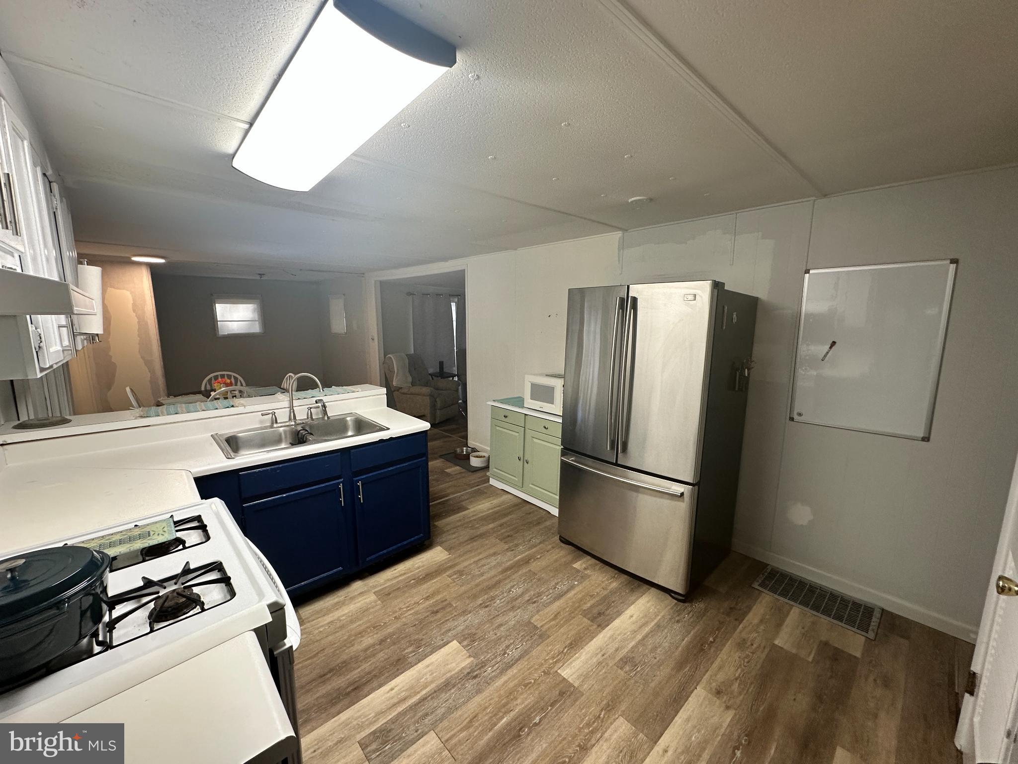 34481 Broad Water Road, Unit 643 Long Neck, DE 19966 - Photo 6 of 21 a large kitchen with stainless steel appliances a refrigerator and a stove top oven