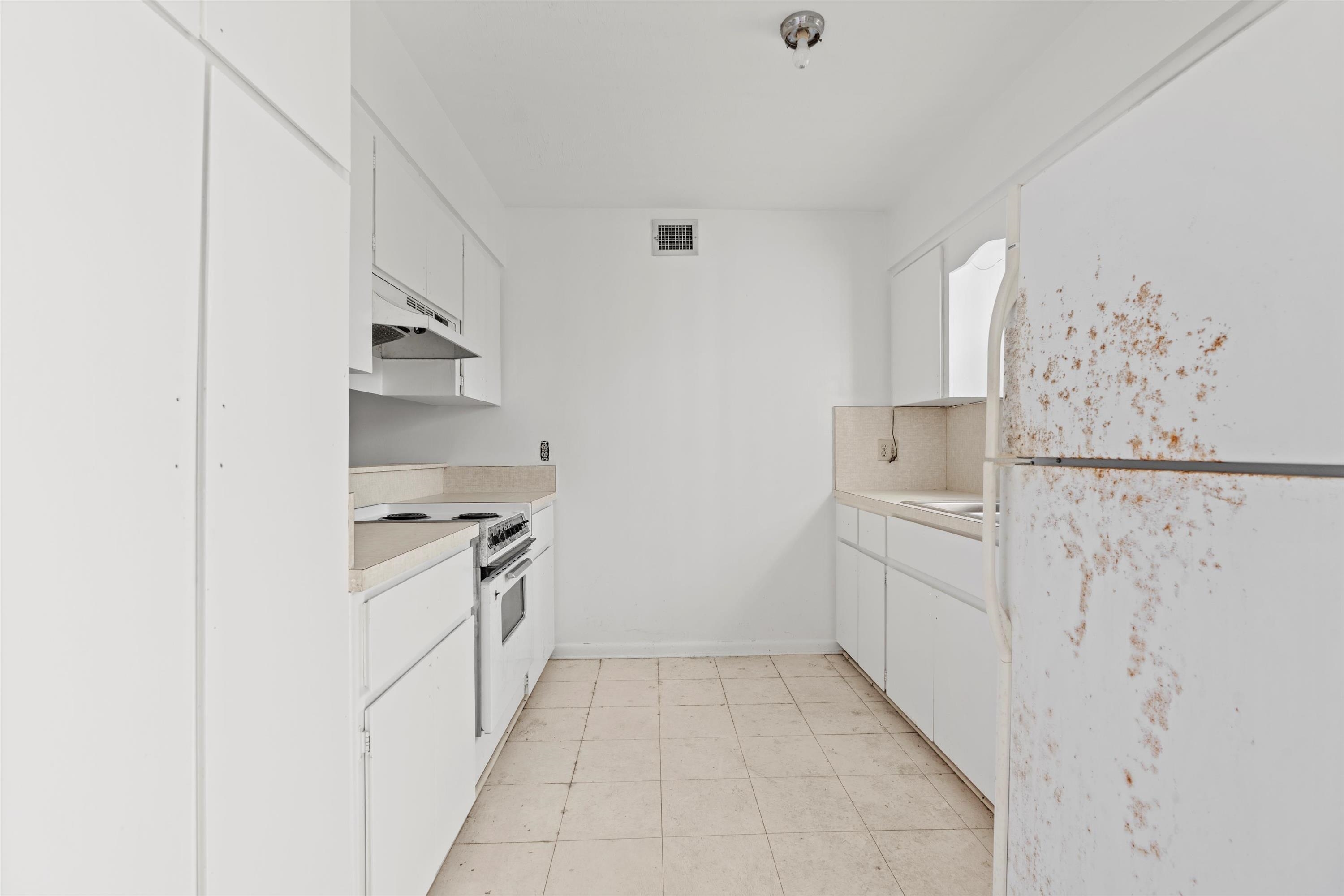 22 Comares Avenue, Unit 5B St. Augustine, FL 32080 - Photo 12 of 23 a kitchen with white cabinets and white appliances