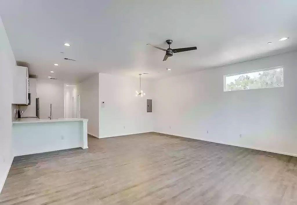 3275 Dallas Street, Unit 104 Dallas, TX 75210 - Photo 3 of 9 Unfurnished living room featuring ceiling fan, light wood-style flooring, and hanging lights