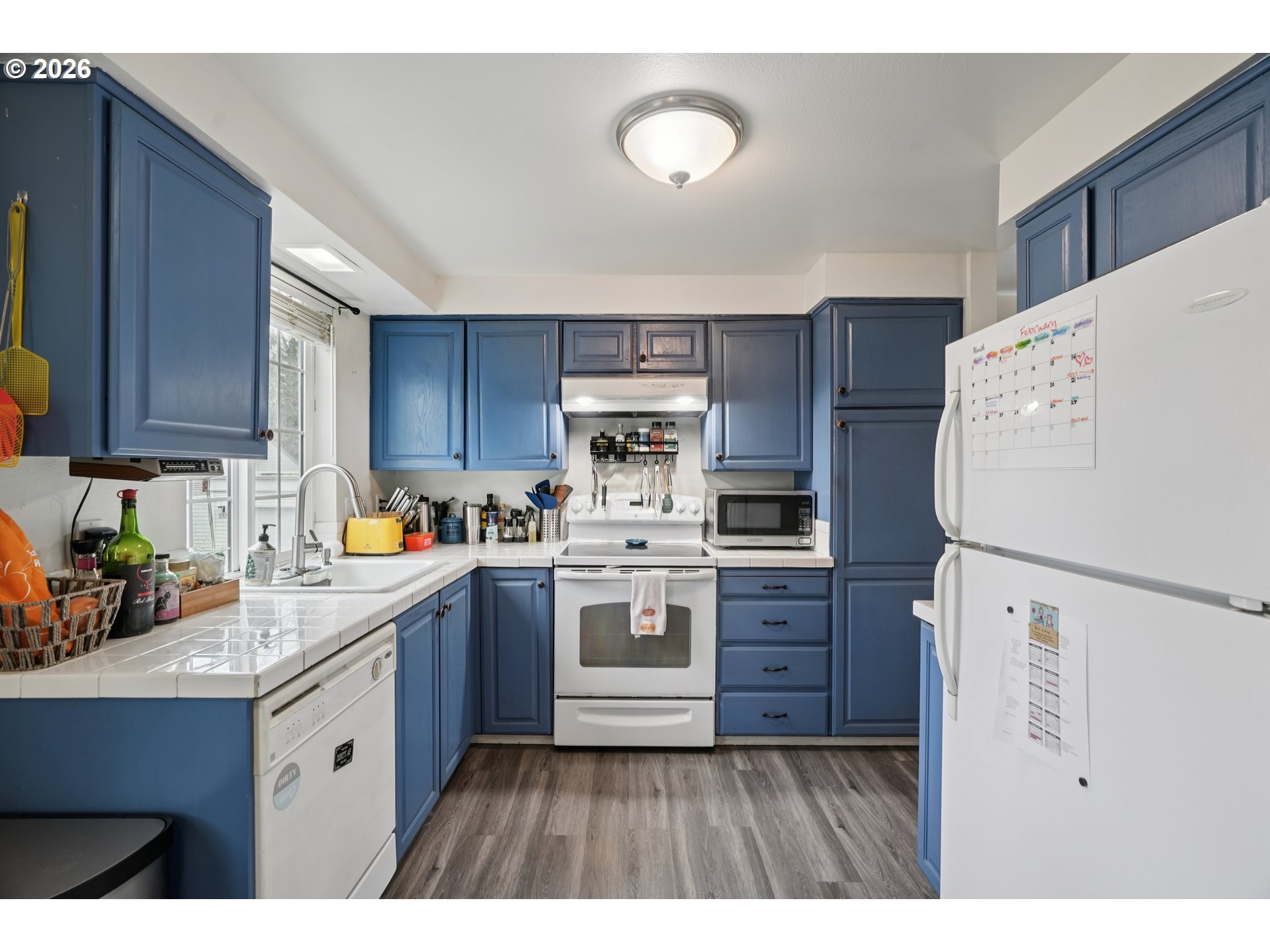 13050 Southwest 17th Street Beaverton, OR 97008 - Photo 15 of 35 a kitchen with stainless steel appliances a refrigerator a sink a stove a microwave and wooden cabinets