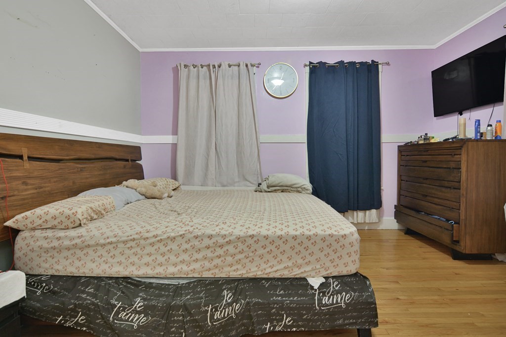 210 Ferry Street Lawrence, MA 01841 - Photo 14 of 24 a bedroom with a bed and flat screen tv