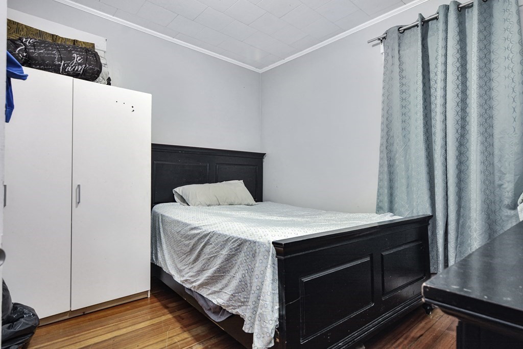 210 Ferry Street Lawrence, MA 01841 - Photo 22 of 24 a bedroom with a bed and a cabinets