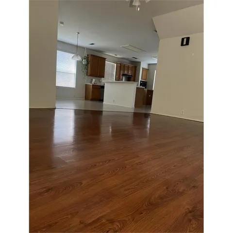 a view of a living room with kitchen island granite countertop wooden floor