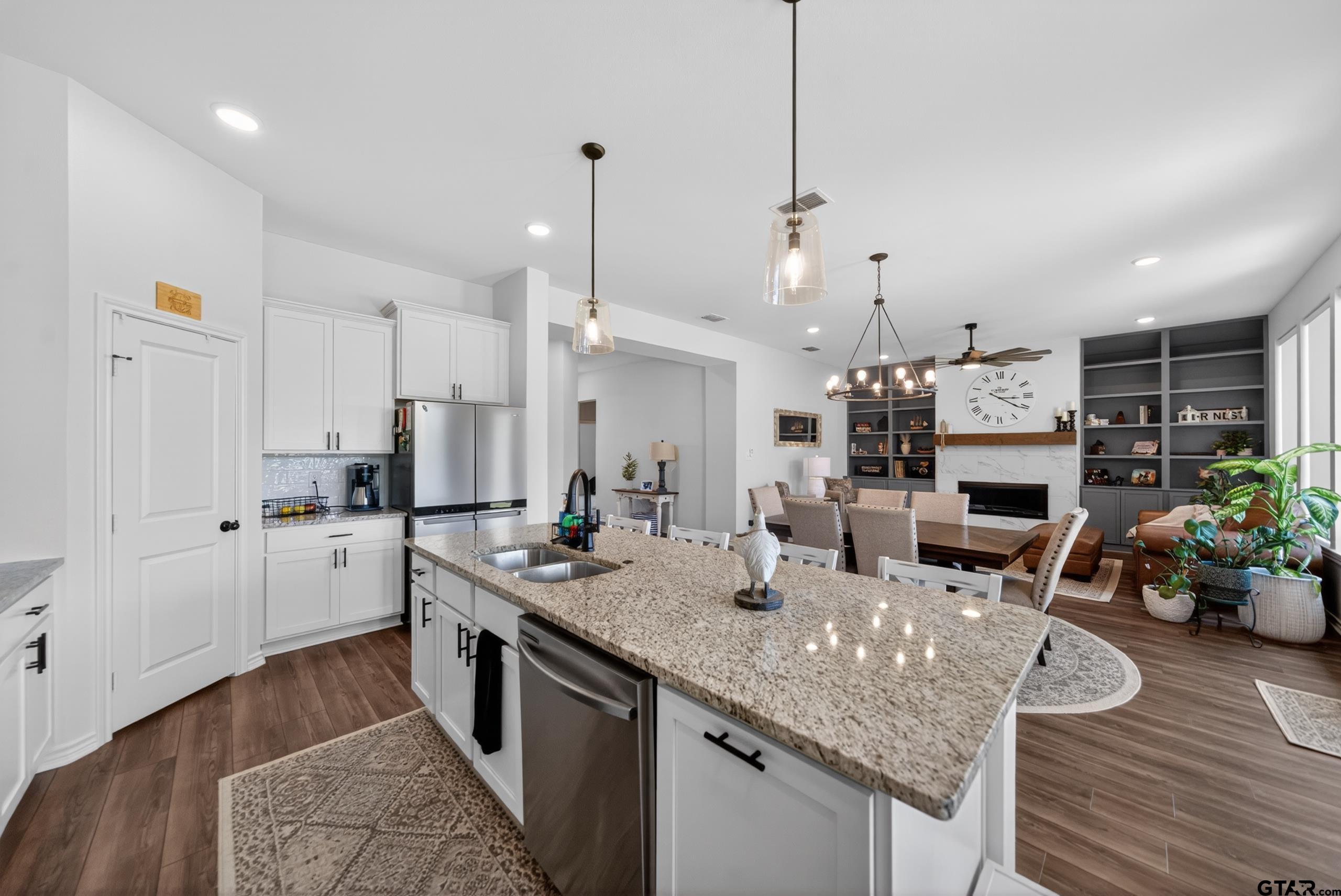 7836 Freestone Drive Bullard, TX 75757 - Photo 7 of 43 a kitchen with stainless steel appliances granite countertop a kitchen island hardwood floor sink stove and white cabinets