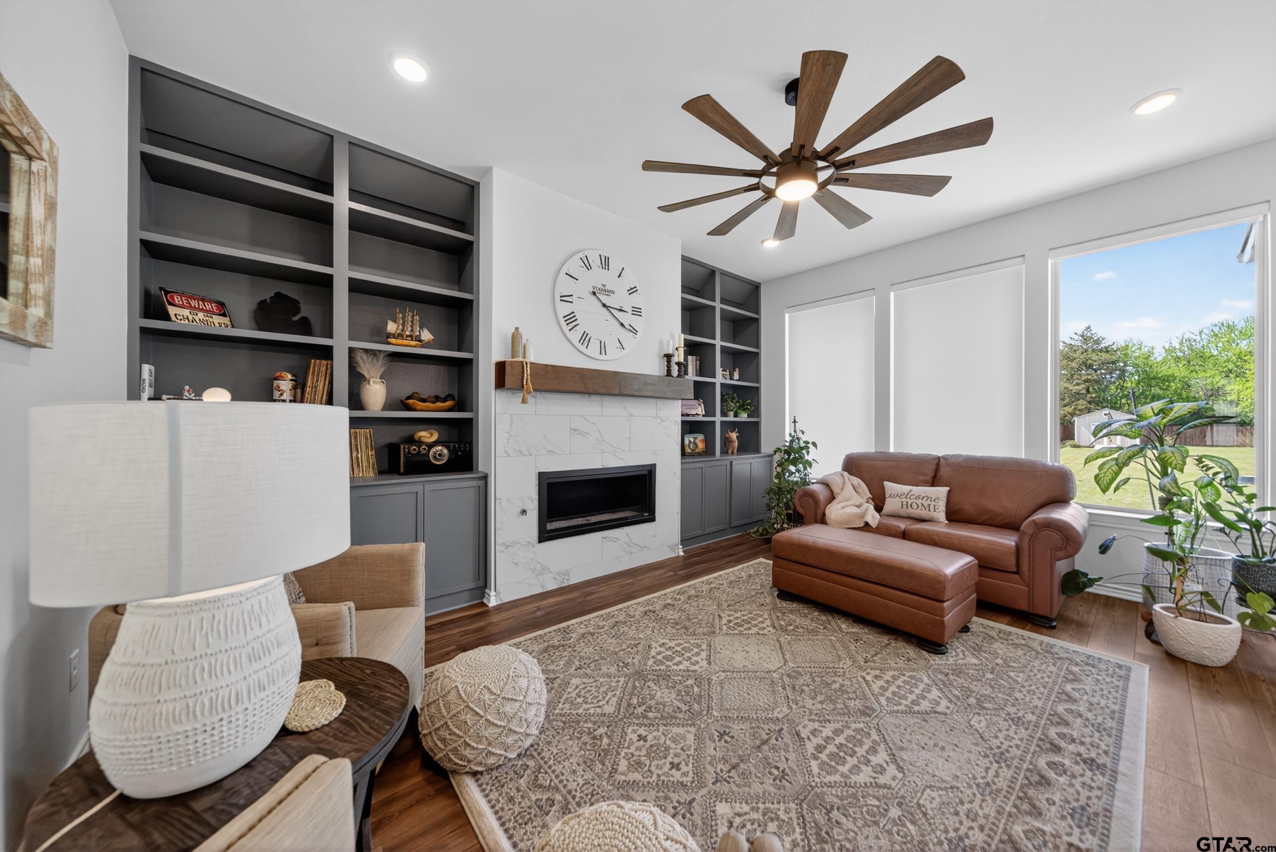 7836 Freestone Drive Bullard, TX 75757 - Photo 9 of 43 a living room with furniture a ceiling fan and a fireplace