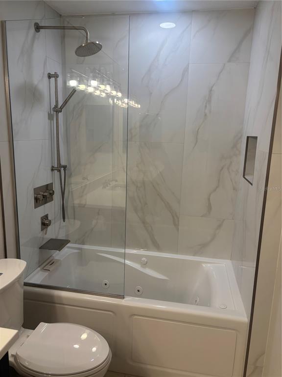 6536 Moorings Point Circle, Unit 101 Lakewood Ranch, FL 34202 - Photo 12 of 34 a bathroom with a toilet and a shower