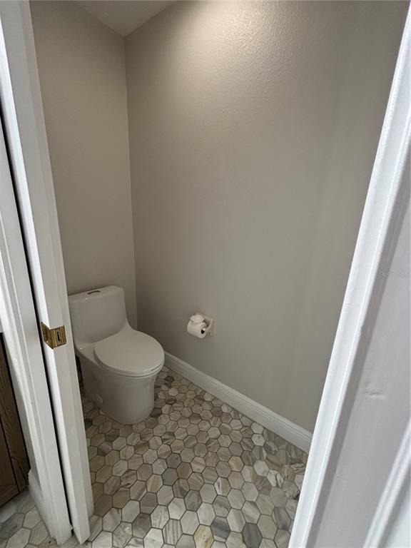 6536 Moorings Point Circle, Unit 101 Lakewood Ranch, FL 34202 - Photo 27 of 34 a bathroom with a toilet and a shower