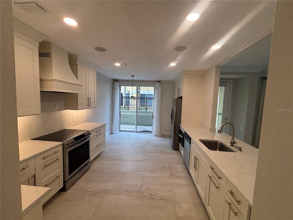 6536 Moorings Point Circle, Unit 101 Lakewood Ranch, FL 34202 - Photo 3 of 34 a large kitchen with stainless steel appliances granite countertop a stove and a sink