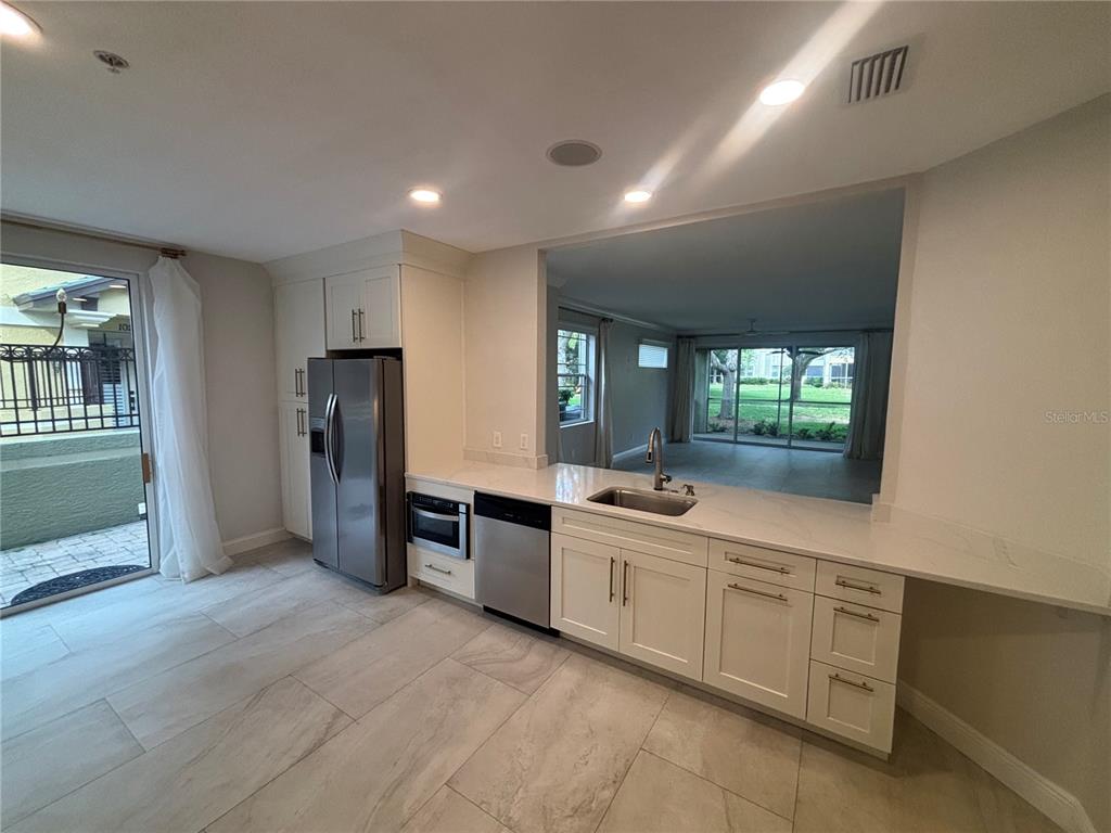 6536 Moorings Point Circle, Unit 101 Lakewood Ranch, FL 34202 - Photo 4 of 34 a large kitchen with stainless steel appliances a refrigerator and a sink