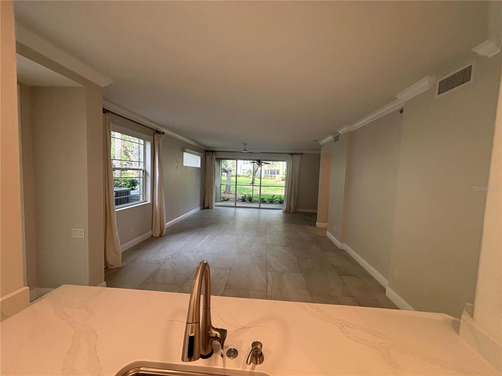 6536 Moorings Point Circle, Unit 101 Lakewood Ranch, FL 34202 - Photo 7 of 34 a view of an empty room with wooden floor and a window
