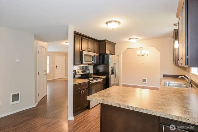 a kitchen with granite countertop a sink stove and refrigerator
