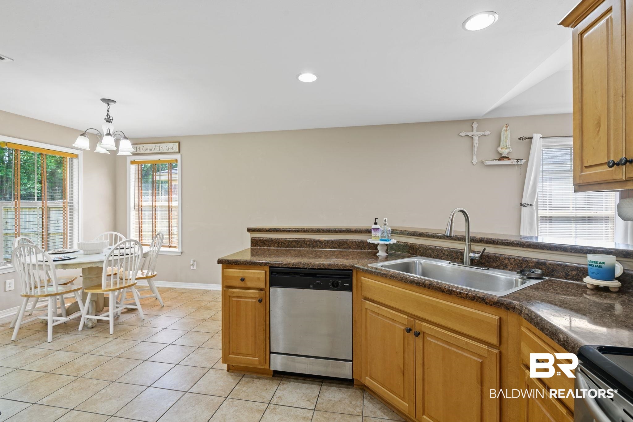 8956 Spring Grove North Mobile, AL 36695 - Photo 8 of 19 Kitchen with dishwasher, a sink, a chandelier, dark countertops, and light tile patterned floors