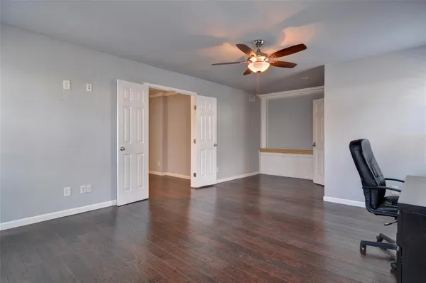 a view of a workspace with wooden floor and a ceiling fan