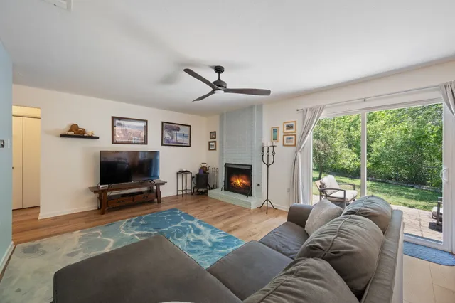 a kitchen with stainless steel appliances kitchen island granite countertop a refrigerator a stove a sink a dining table and chairs with wooden floor