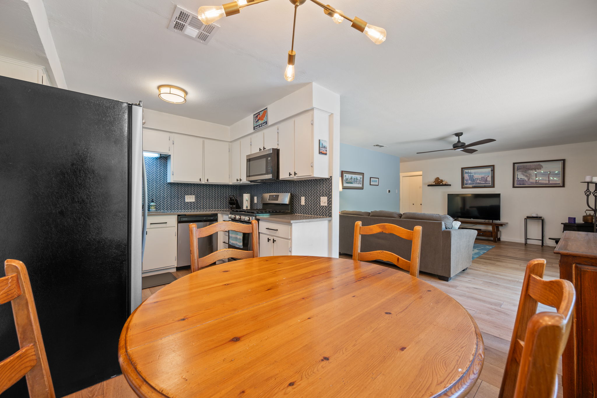 2801 Cornish Circle Austin, TX 78745 - Photo 9 of 29 a kitchen with stainless steel appliances kitchen island granite countertop a refrigerator a stove a sink a dining table and chairs with wooden floor