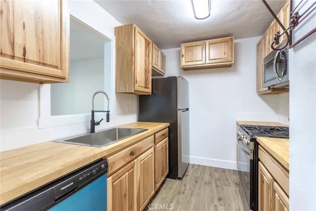 a kitchen with stainless steel appliances granite countertop a stove a sink and a microwave