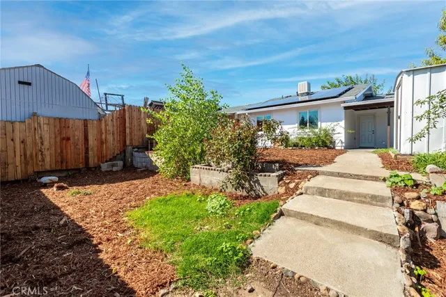 a view of a backyard with potted plants and wooden fence