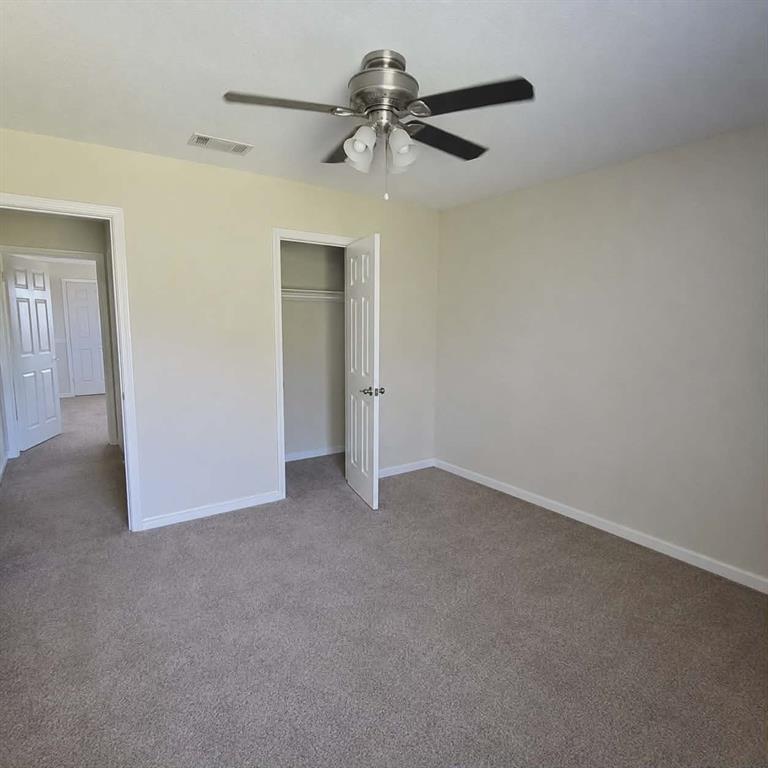14752 Ranch Road Forney, TX 75126 - Photo 24 of 40 Bedroom 2- Interior room featuring neutral-toned walls, plush carpet flooring, and a ceiling fan with integrated lighting-This photo was taken before family moved in