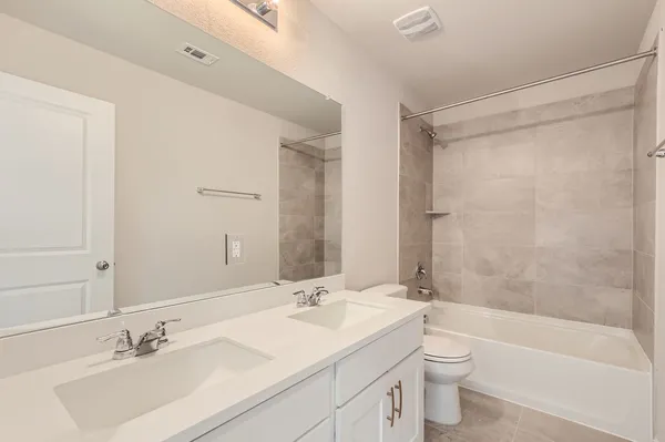 a bathroom with a sink mirror toilet and bathtub