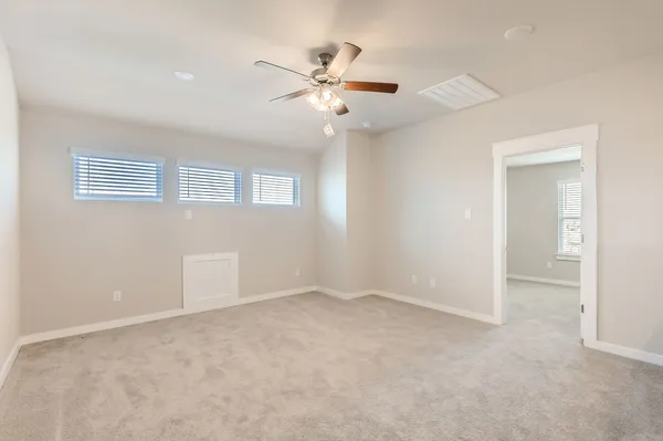 a view of an empty room with a ceiling fan
