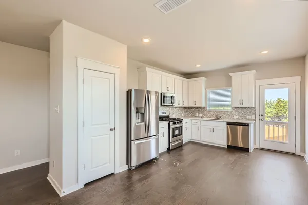 a kitchen with a refrigerator stove top oven and sink