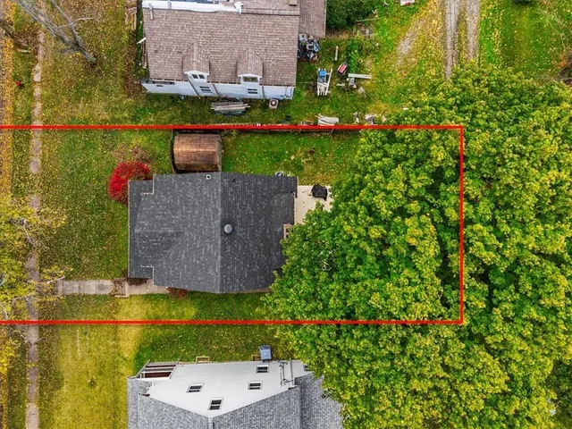 an aerial view of a house with a garden and lake view