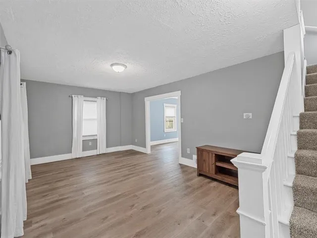a view of a livingroom with wooden floor and a fireplace