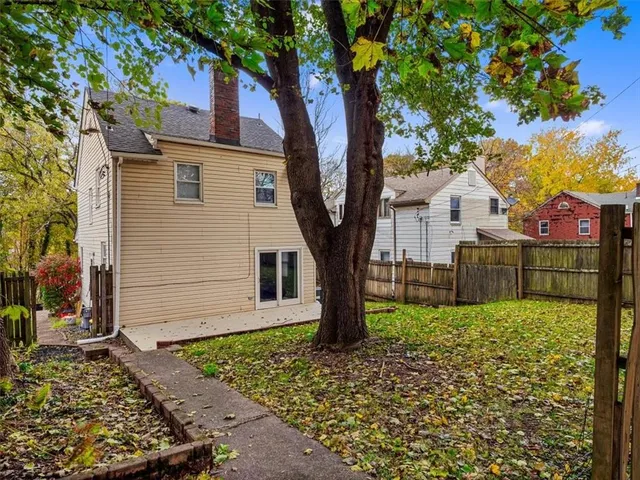 a white house that has tree in front of it
