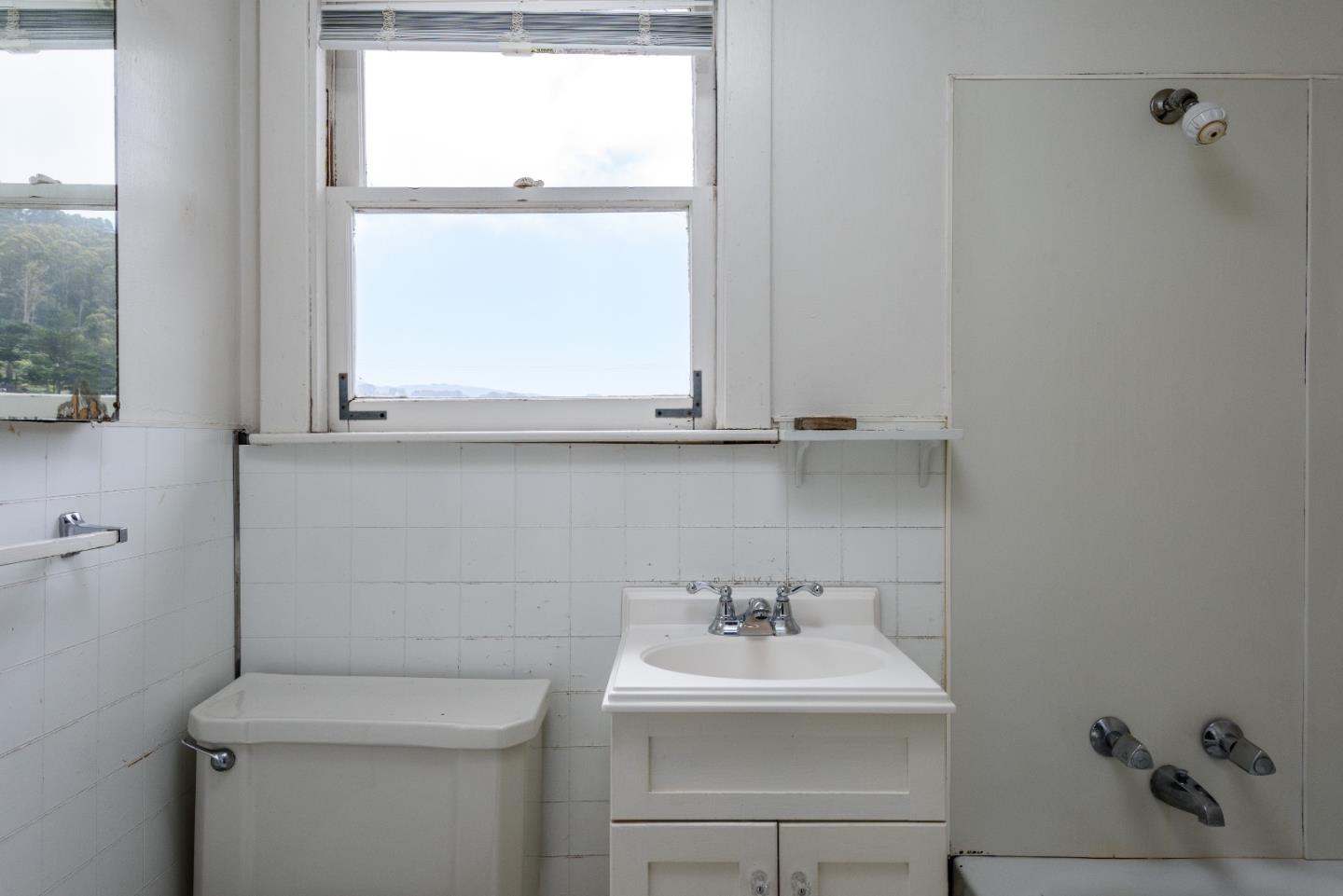 276 Kent Road Pacifica, CA 94044 - Photo 8 of 15 a bathroom with a sink a toilet and a mirror
