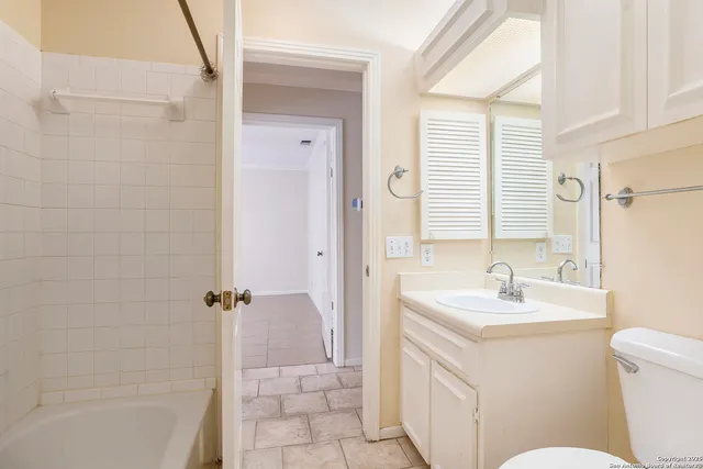 a bathroom with a sink toilet vanity and tub