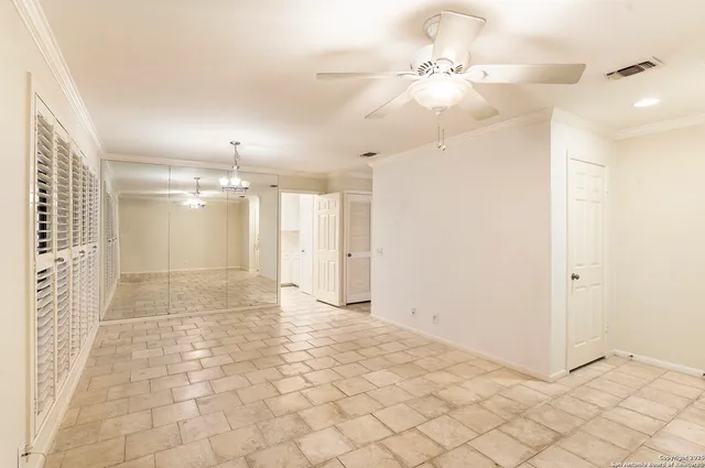 a view of a hallway with a chandelier fan and windows