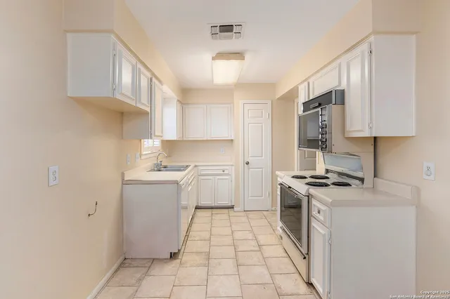 a kitchen with a stove sink and cabinets