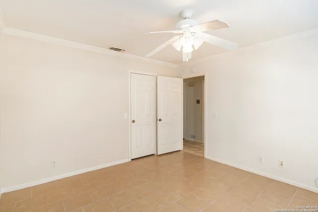 an empty room with a ceiling fan and a window