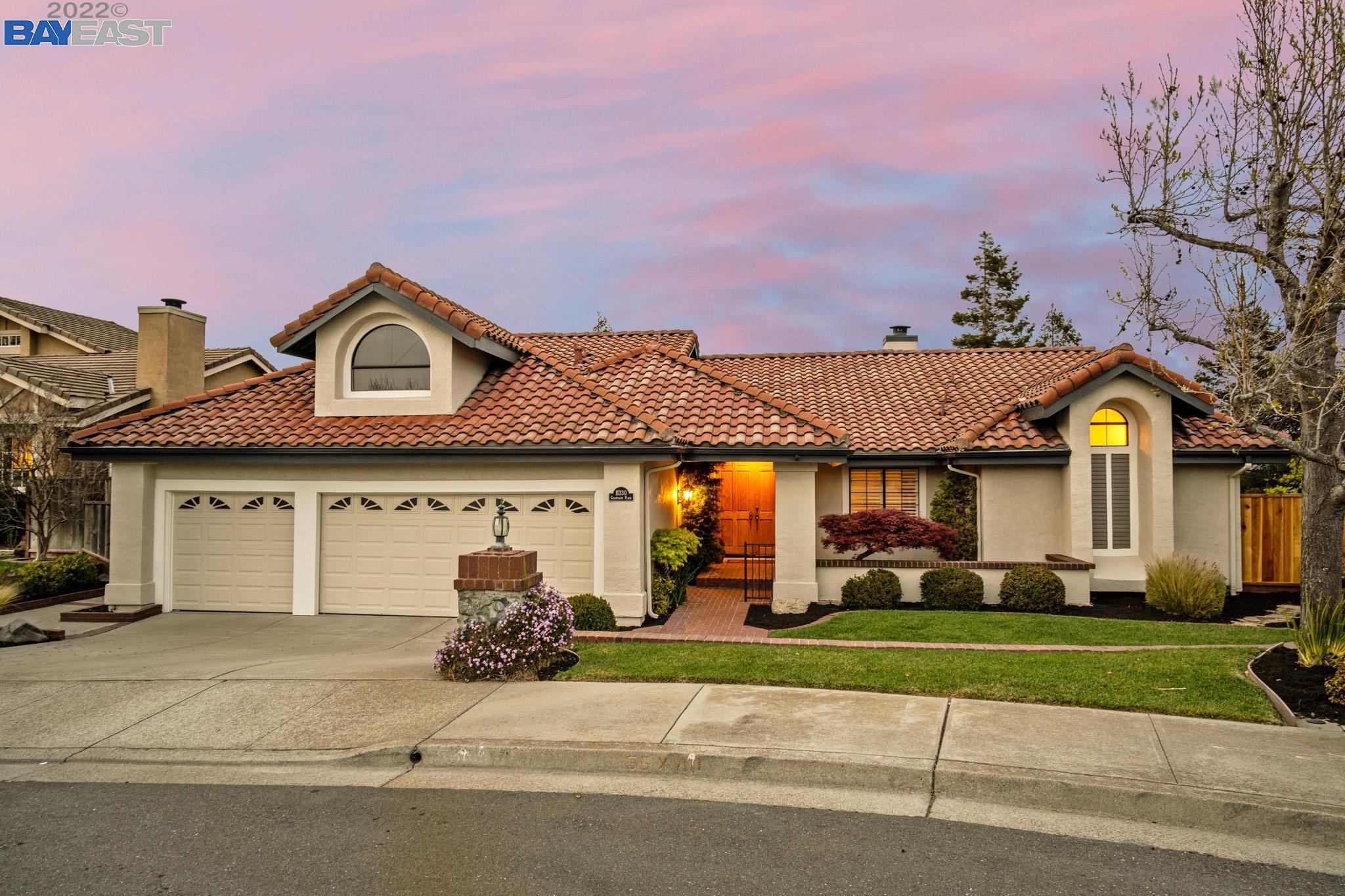 a front view of a house with a garden and garage