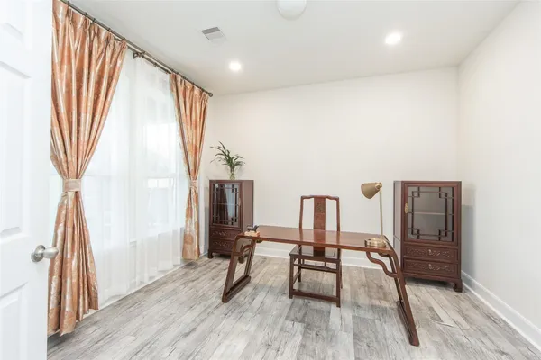 a spacious bedroom with a bed and a flat screen tv