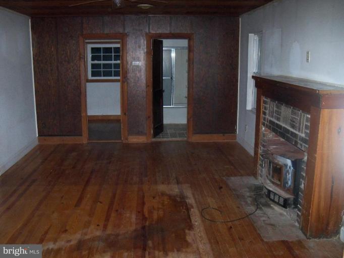 4496 Baptist Road Taneytown, MD 21787 - Photo 8 of 13 a view of empty room with wooden floor and fireplace