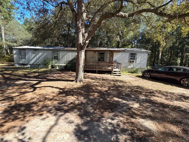a backyard of a house with barbeque oven and outdoor seating