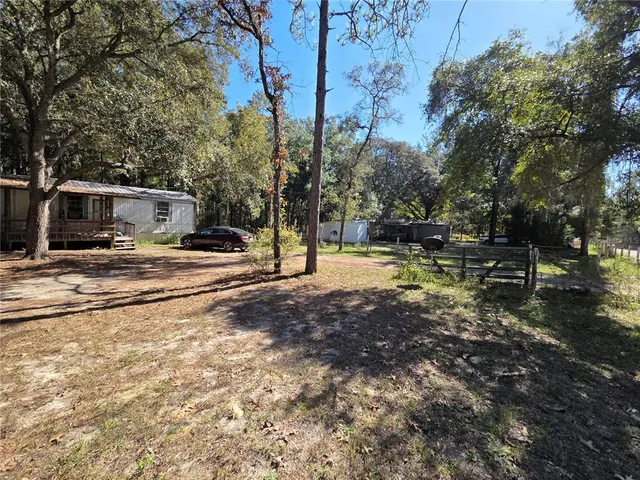 a backyard of a house with barbeque oven table and chairs