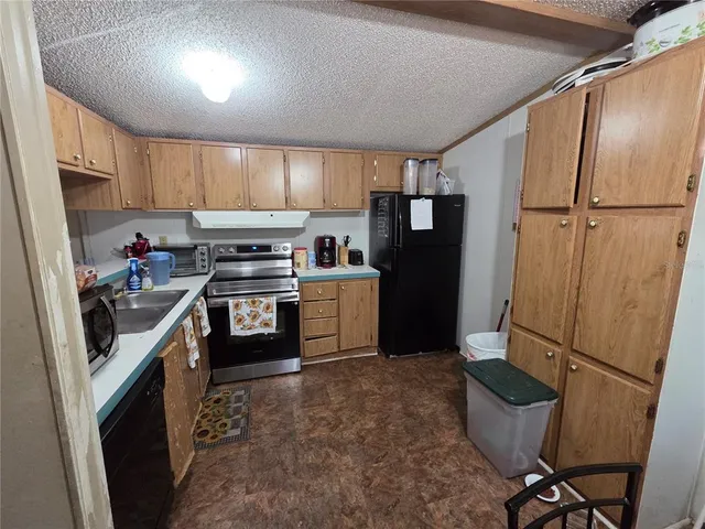 a kitchen with granite countertop a refrigerator and a sink