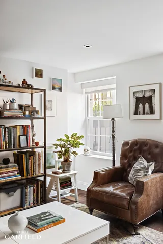 a living room with furniture and a book shelf