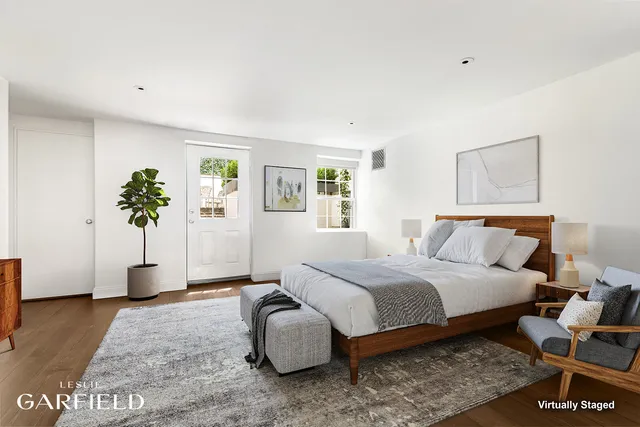a spacious bedroom with a bed and a potted plant